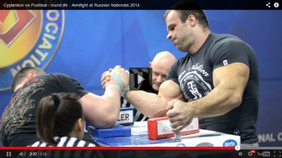 Andrey Pushkar vs. Denis Cyplenkov - Armfight at Russian National Armwrestling Championship 2014 │ Print Screen edited by XSportNews.com from the Cyplenkov vs Pushkar - round #4 - Armfight at Russian Nationals 2014 video