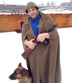 Denis Cyplenkov with a rifle, combat helmet - battle helmet, army coat and a dog