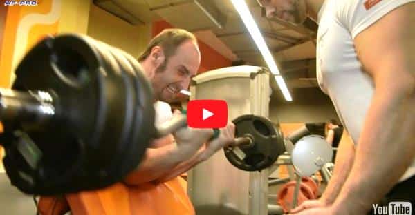 Maxim Cherskiy, top half biceps curls for armwrestling with EZ Curl Bar │ Capture by XSportNews from the video 